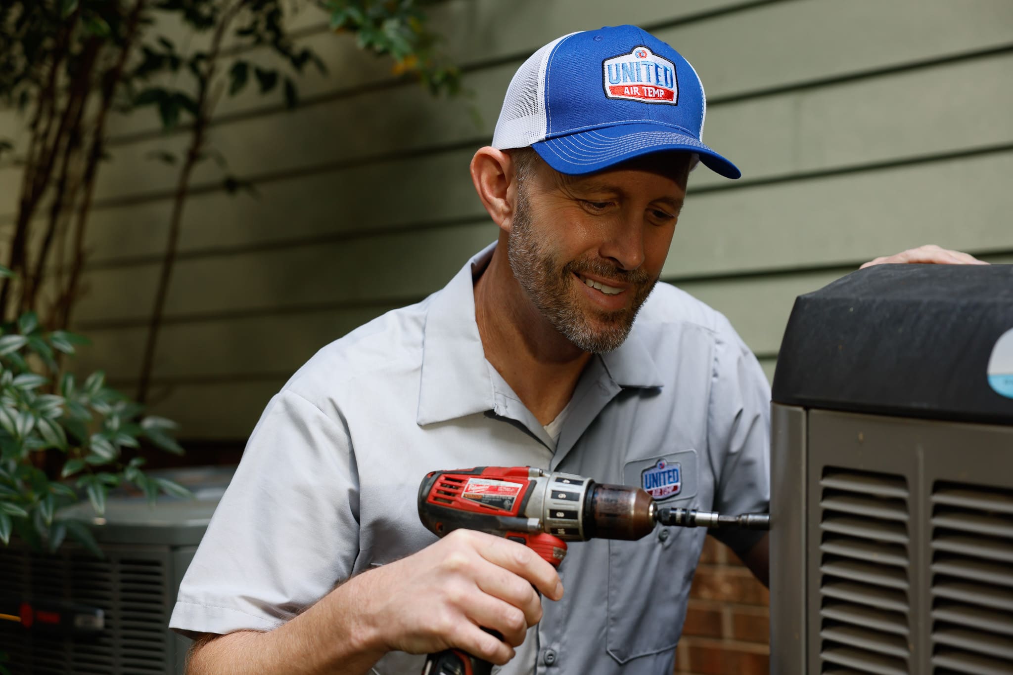 HVAC technician servicing air conditioner