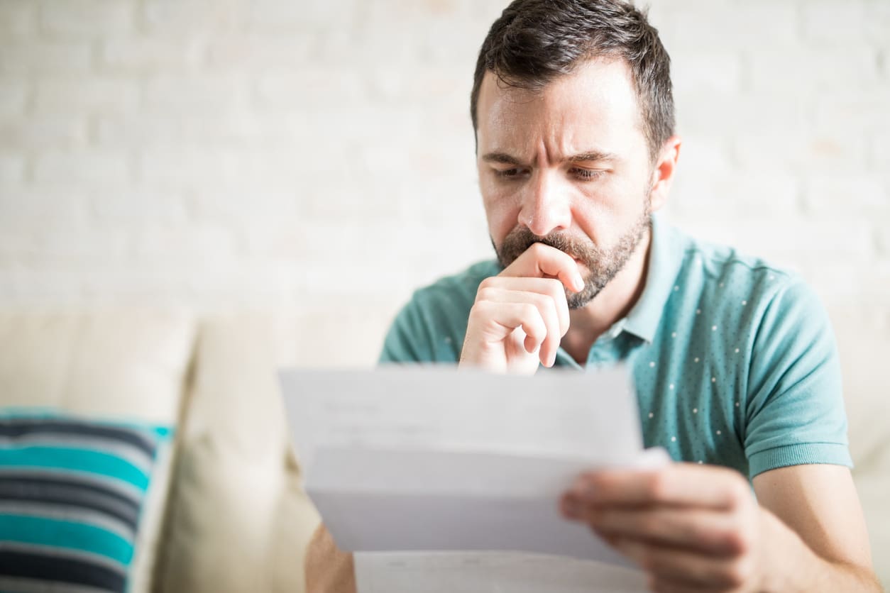 Worried man reading a piece of paper