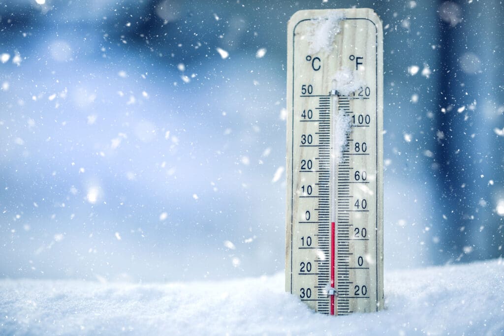Thermometer on snow shows low temperatures - zero.