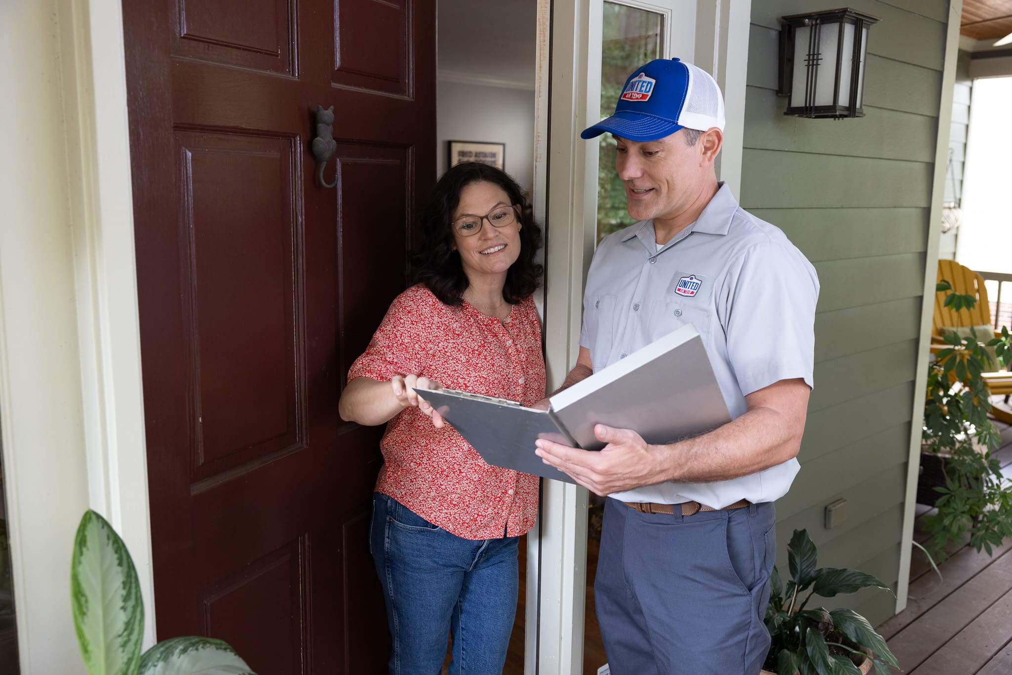 UAT technician talking to a homeowner and looking at a folder