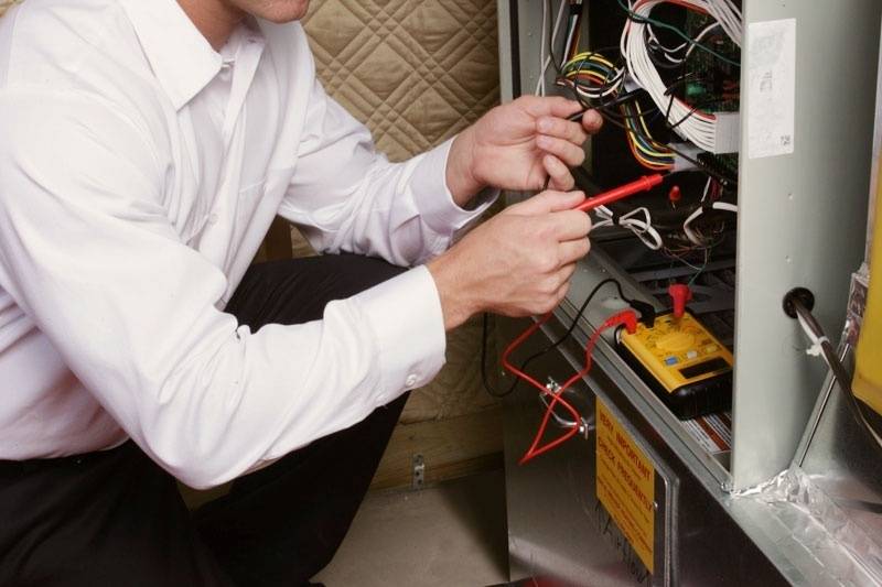 HVAC technician performing furnace maintenance